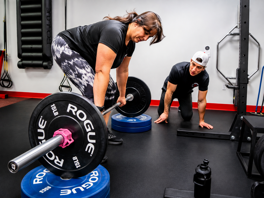 Coach observing members at Revolution Fitness